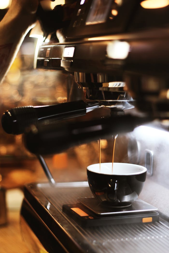 Close-up of espresso brewing process with modern coffee machine indoors.