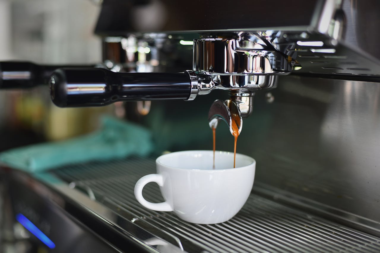 Close-up of espresso pouring from a shiny coffee machine into a white cup, perfect for lovers of caffeine and barista art.
